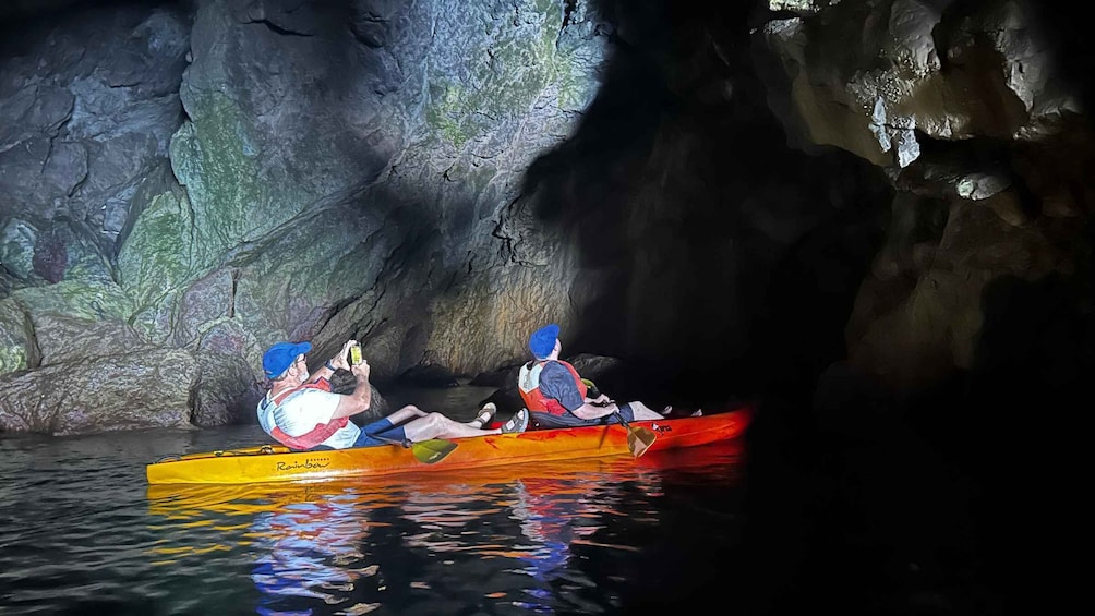 Due persone che fanno kayak in una grotta con pareti rocciose. 4
