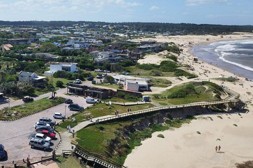 Un pueblo costero con playa, un puente y coches aparcados. 4