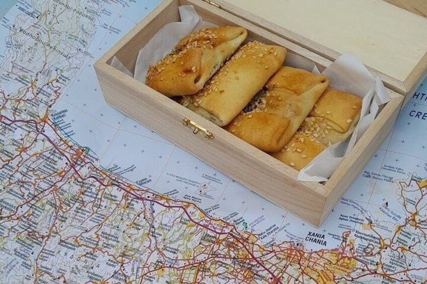 Una caja de madera con pasteles sobre un mapa. 2