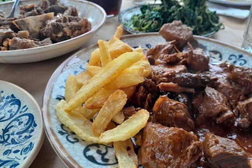 En portion köttgryta med pommes frites och en liten sallad som tillbehör. 4