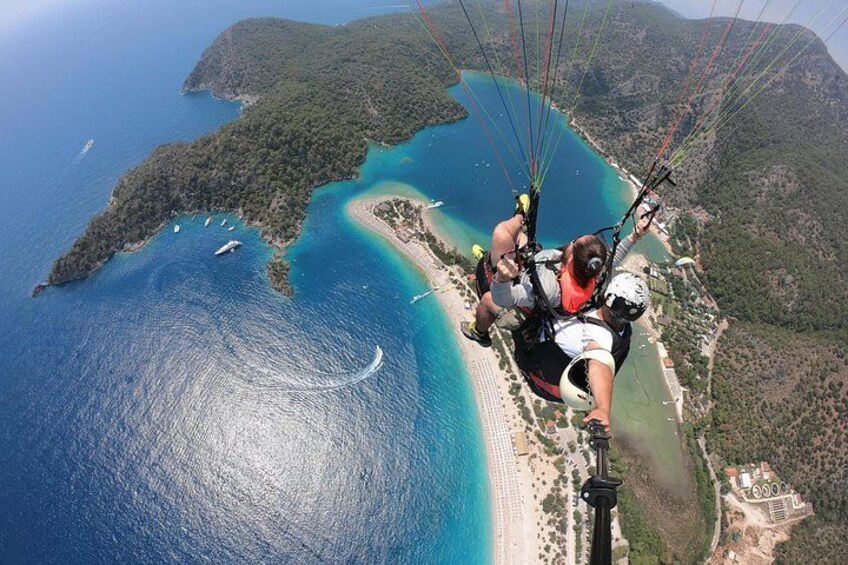 Actividad de parapente sobre una zona costera con playa y aguas azules cristalinas. 3