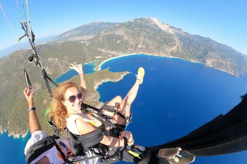 Una persona haciendo paracaidismo, con un paracaídas, observando un paisaje costero con agua y montañas. 2