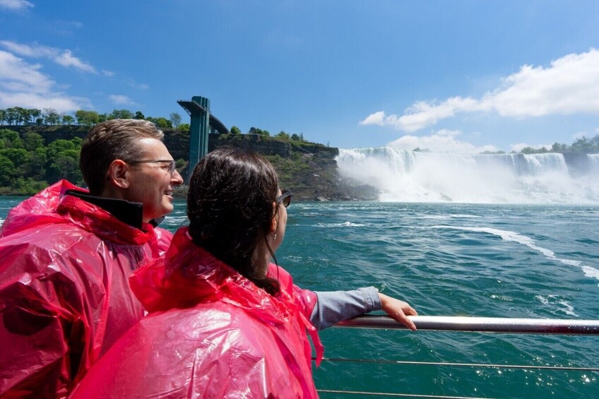 A couple on a boat with a waterfall in the background. 1