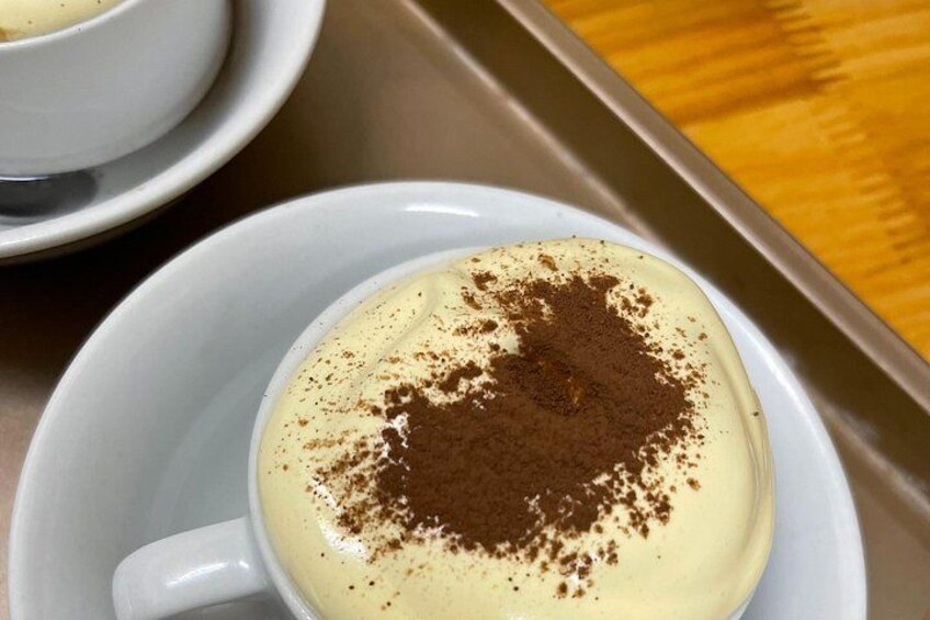 Una taza de café con una capa de espuma y un poco de cacao espolvoreado encima. 5