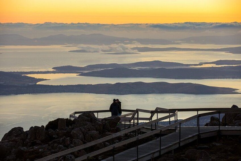 A sunset view from a rocky overlook with a wooden walkway. 5