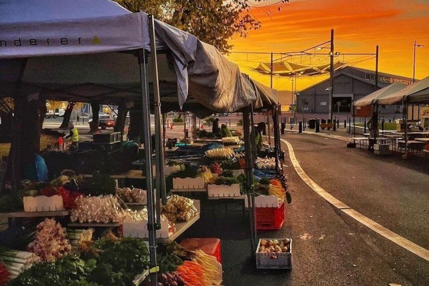 A street market with stalls selling fruits and vegetables. 1