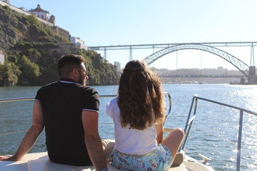 A couple on a boat with a bridge in the background. 3