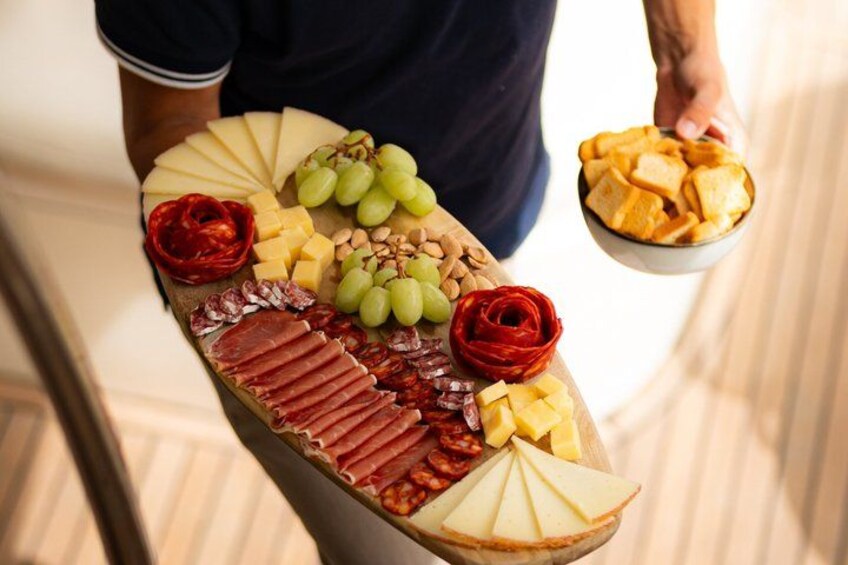 A charcuterie board with various meats, cheeses, grapes, and crackers. 3