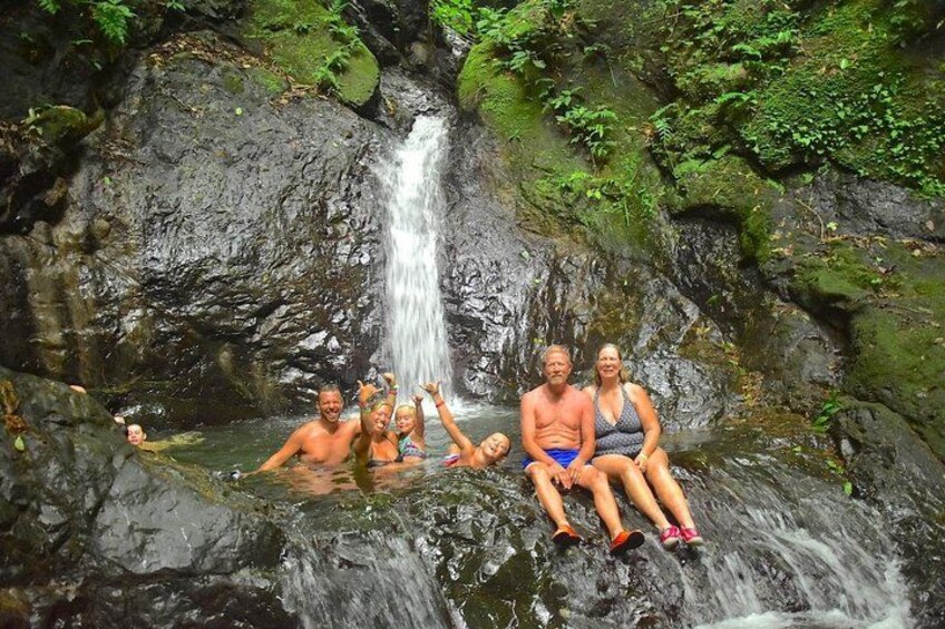 A waterfall, people sitting and relaxing in a natural setting. 2