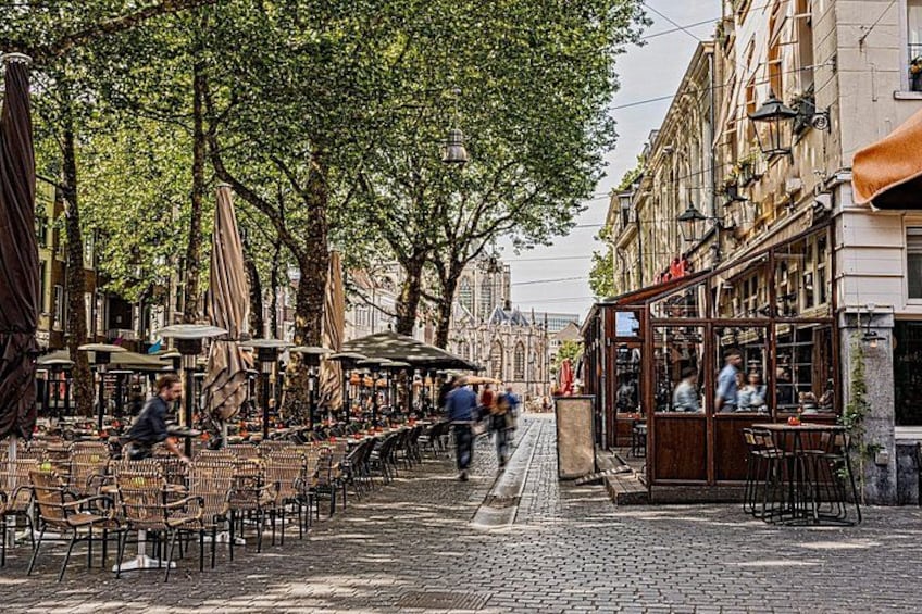 Outdoor seating with umbrellas, a cobblestone street, and historic buildings. 4