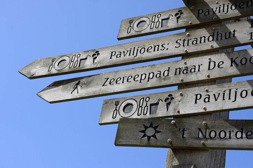 A wooden signpost with multiple directional signs. 5