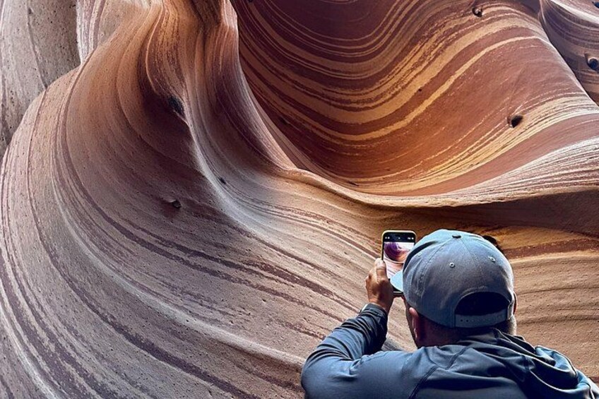 A person taking a photo of a rock formation with a smartphone. 2