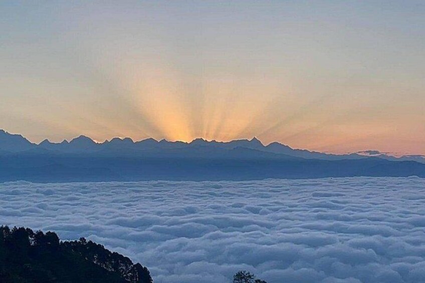 Une chaîne de montagnes au lever du soleil, avec des nuages en contrebas. 5