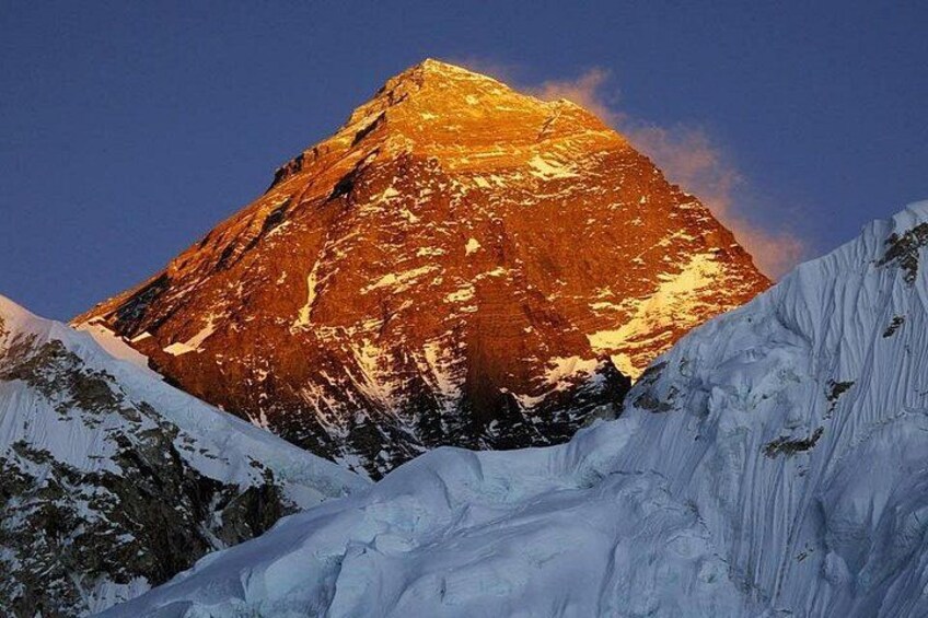 Une montagne enneigée, avec un sommet bien visible illuminé par la lumière du soleil. 1