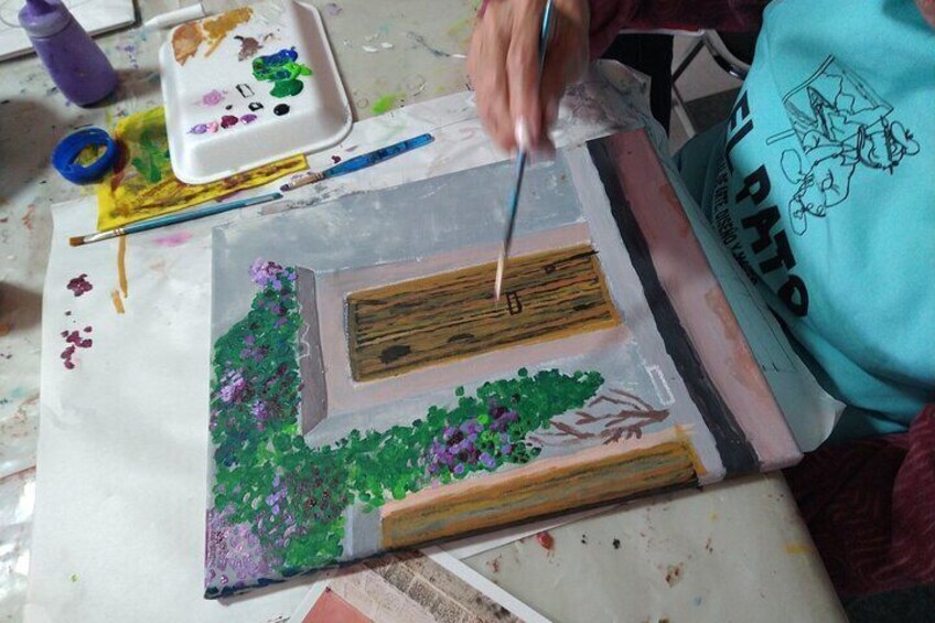 A person painting a landscape with a palette and brushes. 4