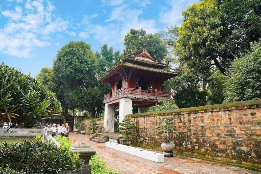 A traditional Chinese pavilion surrounded by lush greenery and a brick wall. 2
