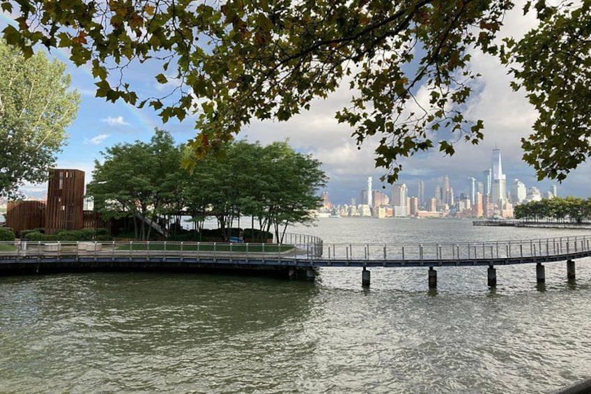 A waterfront with a bridge, trees, and a city skyline in the background. 5