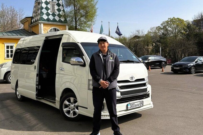 A white van parked in a lot with a building in the background. 2