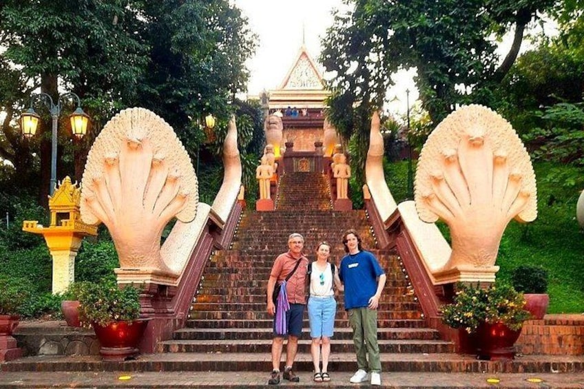 A staircase with large decorative shells, a temple-like structure in the background, and a group of people standing on the steps. 1