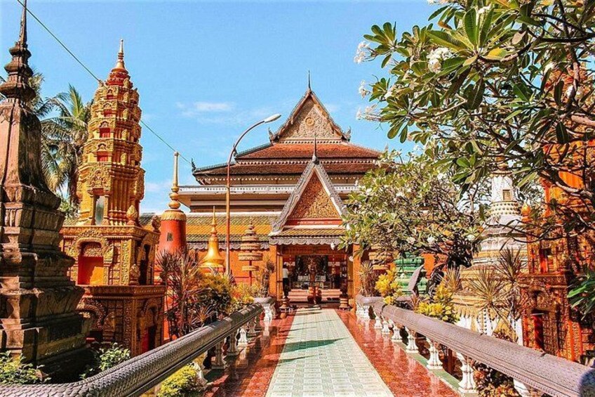 A temple complex with ornate architecture, a central building with a pointed roof, and a long pathway leading to it. 2