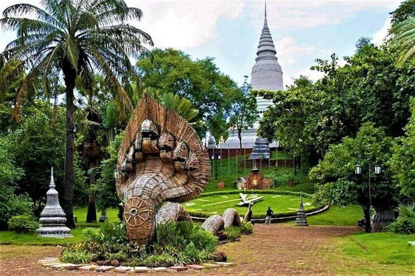 A large sculpture of a mythical creature, a pagoda, and a temple in a lush garden. 4