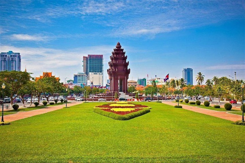A well-maintained park with a central pagoda, surrounded by neatly trimmed grass and flower beds, with modern buildings in the background. 3