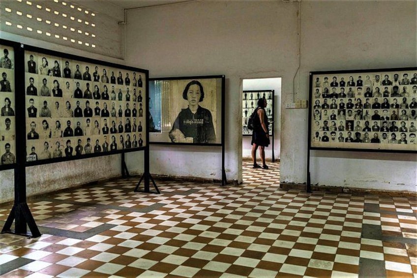 A room with a checkered floor, portraits on the walls, and a person walking in the background. 5