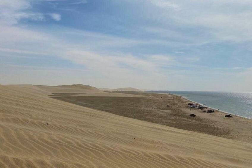 Un paysage désertique avec des dunes de sable et une plage. 2