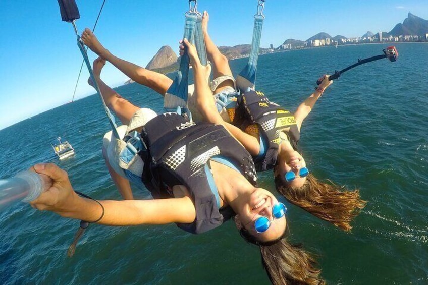 Two people bungee jumping from a boat, wearing safety harnesses and goggles. 1