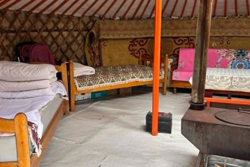 En traditionel yurts med to senge, en central træstolpe og dekorative mønstre på væggene. 4