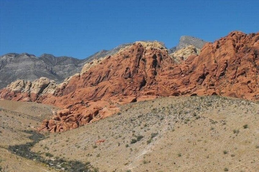A desert landscape with red rock formations and a clear blue sky. 3