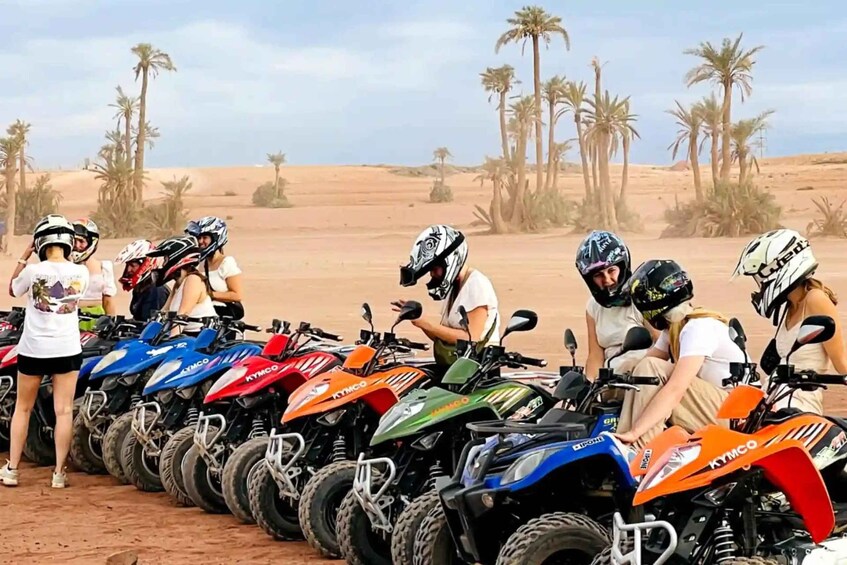 A group of people with quad bikes lined up in a desert. 1