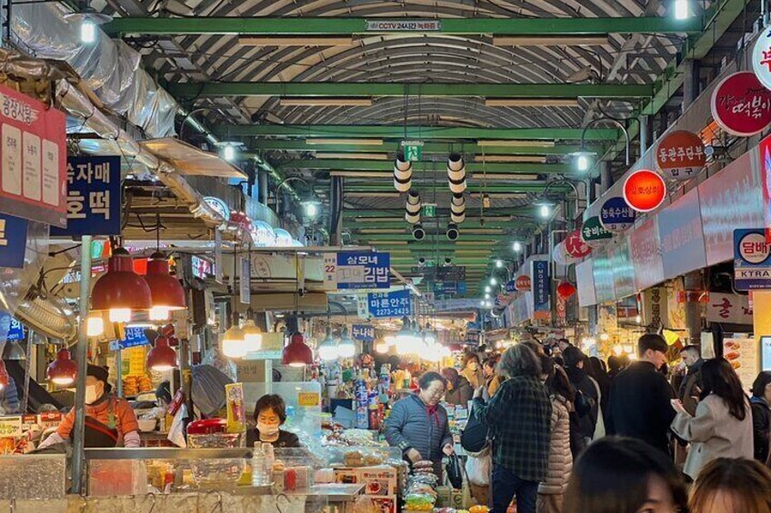 A crowded indoor market with various stalls and hanging signs. 4