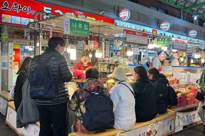 A bustling street market with various stalls selling fruits and vegetables. 5