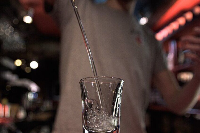 A bartender pouring a drink into a glass. 5
