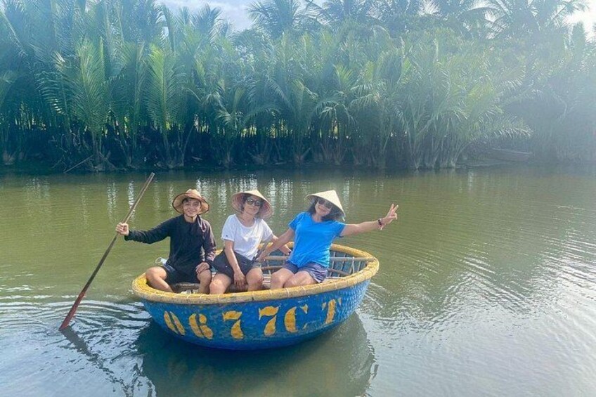 Three people in a boat on a river surrounded by palm trees. 3