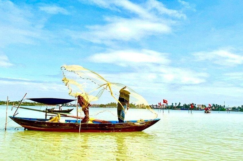 A person fishing from a small boat with a net. 5