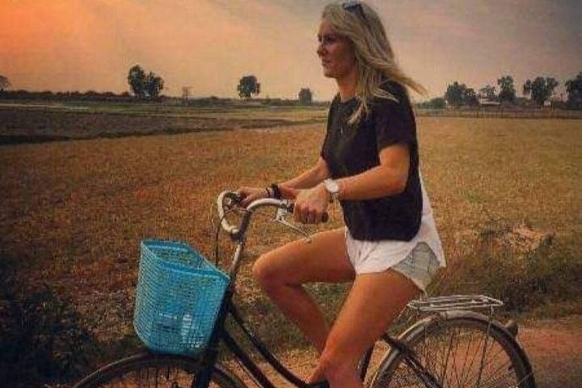 Eine Person fährt mit einem Fahrrad und einem Korb durch ein Feld. 4