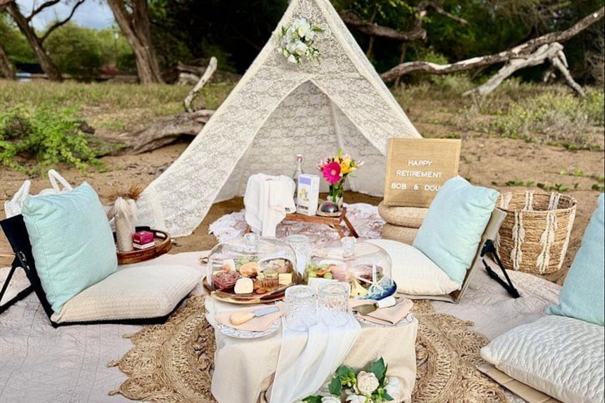 A cozy outdoor seating area with a tent, cushions, and a picnic setup. 3