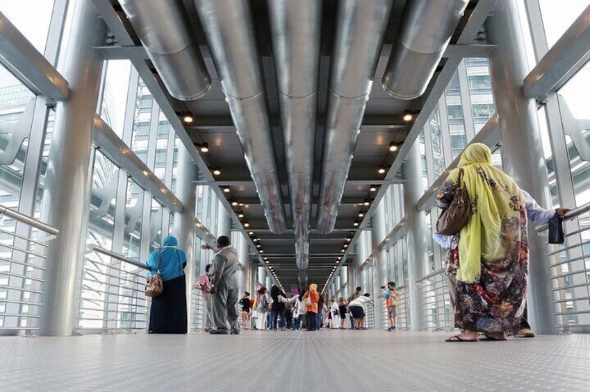 A covered pedestrian walkway with metal beams and glass railings. 3