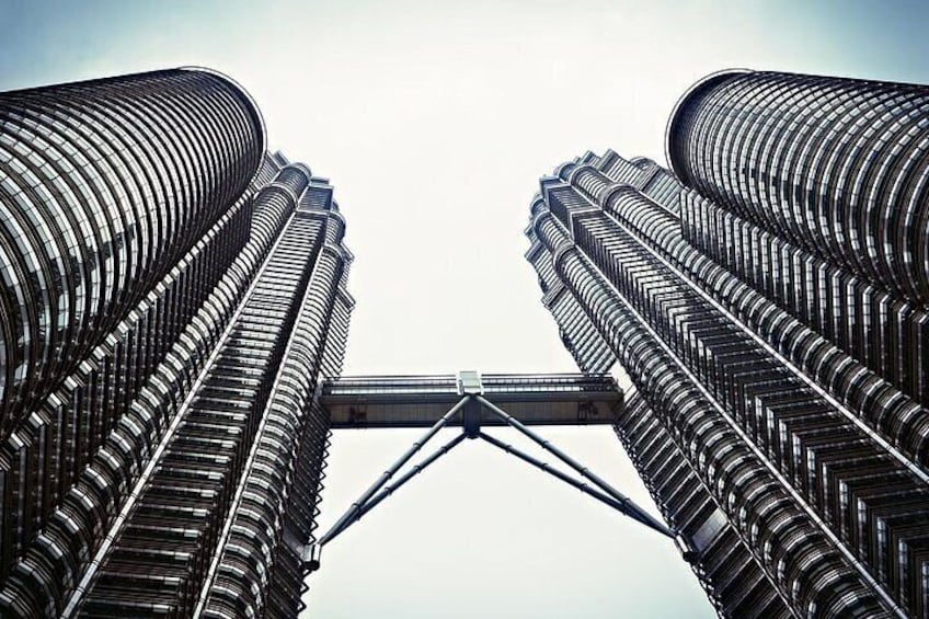 Two tall buildings with a bridge connecting them. 1