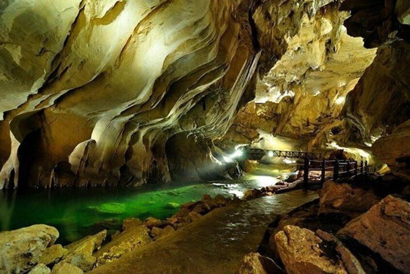 A cave with a wooden bridge over a water stream. 4