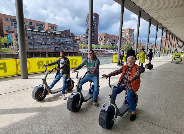 Personas montando segways en un pasillo cubierto, con edificios al fondo. 4