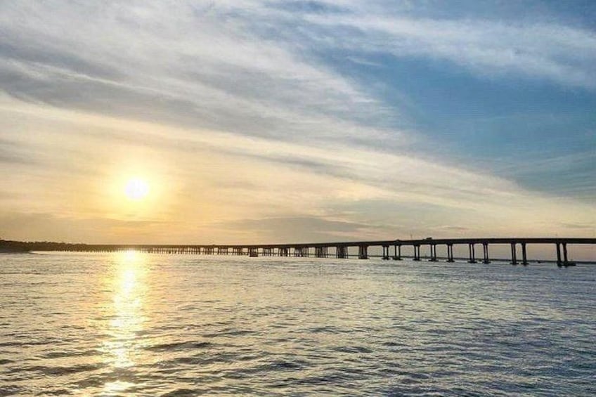 Un muelle se adentra en aguas tranquilas con un atardecer de fondo. 5
