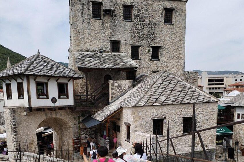 Ein historisches Steinhaus mit einem Turm, einem kleinen Anbau und einer Treppe, die zum Turm führt. 2