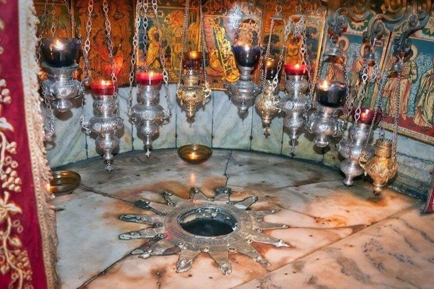 L’intérieur d’un temple, avec des lampes en laiton suspendues et un motif central en forme de soleil sur le sol. 3