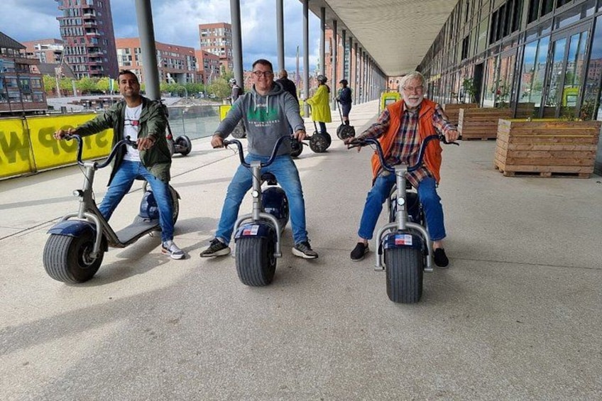 Tres personas paseando en patinetes eléctricos por un camino pavimentado. 3