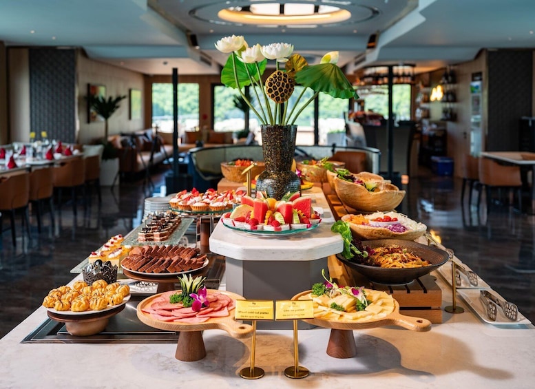Un bufé con diversos alimentos y un centro de mesa decorativo con flores. 2