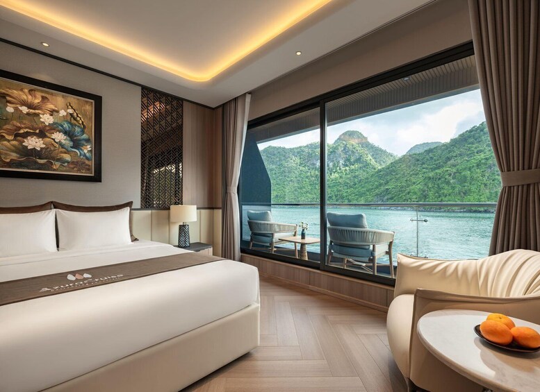 Habitación de hotel con cama, escritorio, silla y vistas a un lago y montañas. 4
