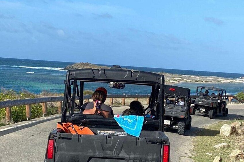 A group of jeeps on a coastal road with ocean views. 2